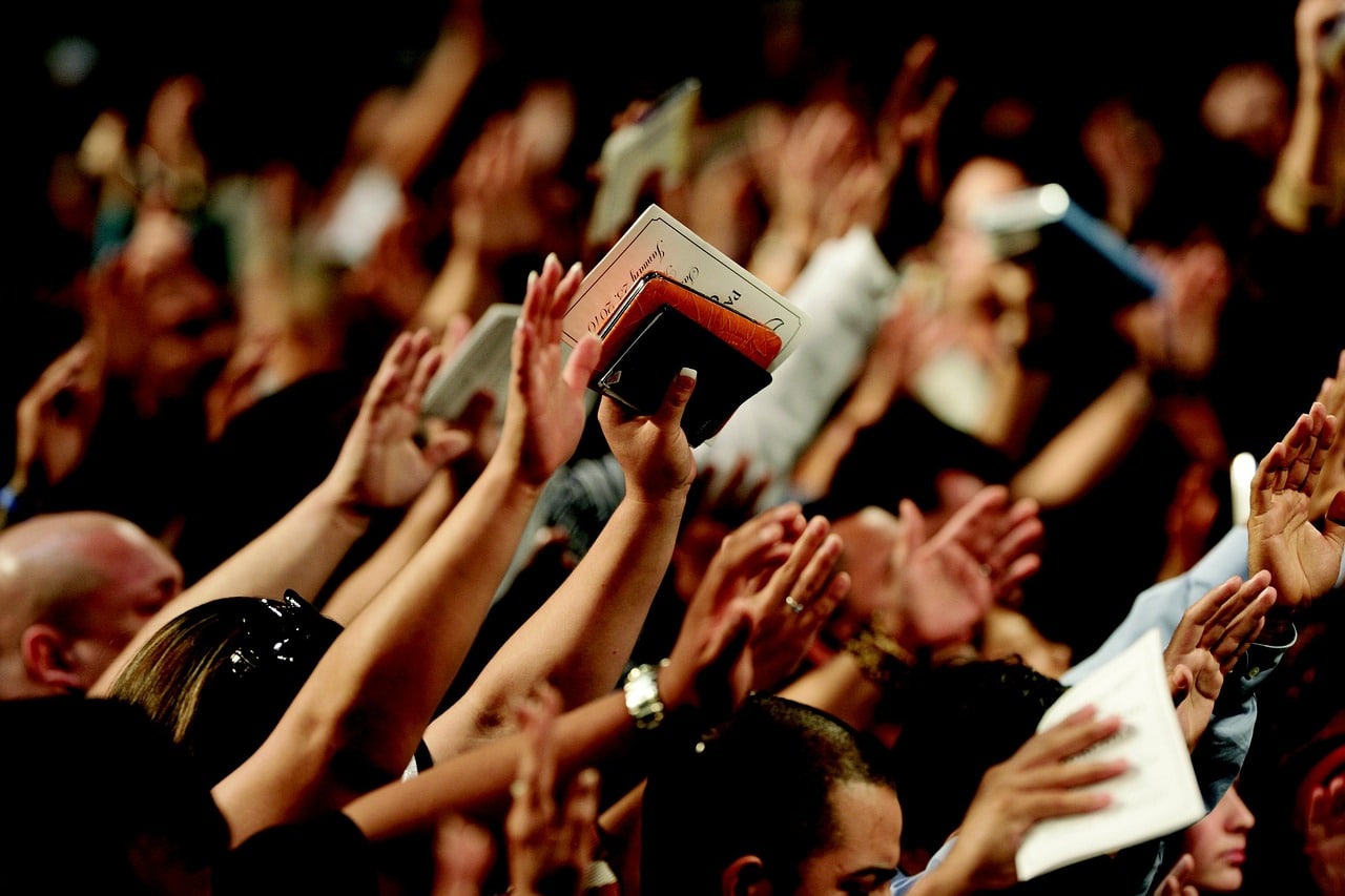 crowd with hands raised in praise