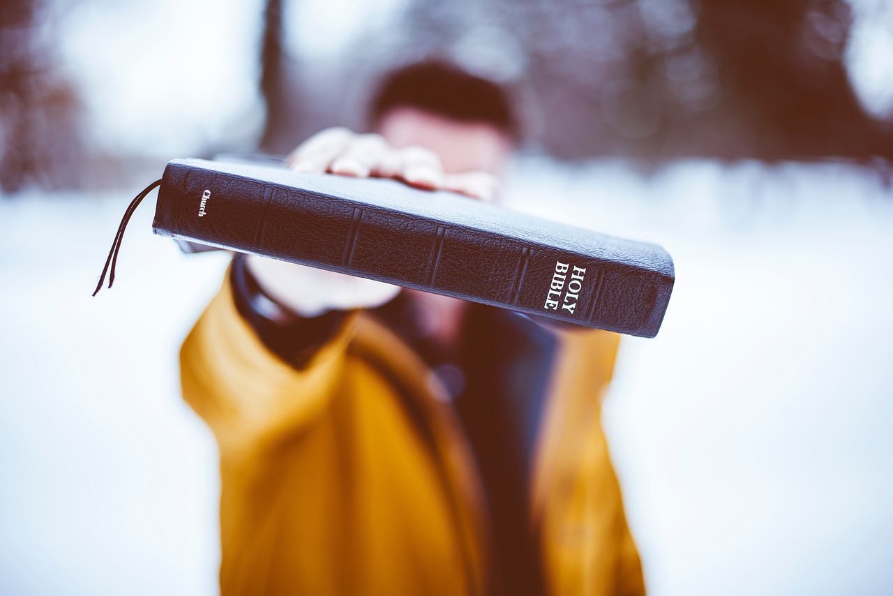 person holding bible up